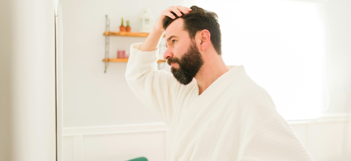 uomo che si guarda allo specchio in bagno